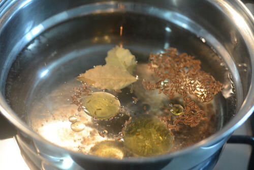 Bring the water to a rolling boil and add 1 teaspoon caraway seeds (shahjeera), 2 bay leaves, 1 teaspoon oil, and some salt
